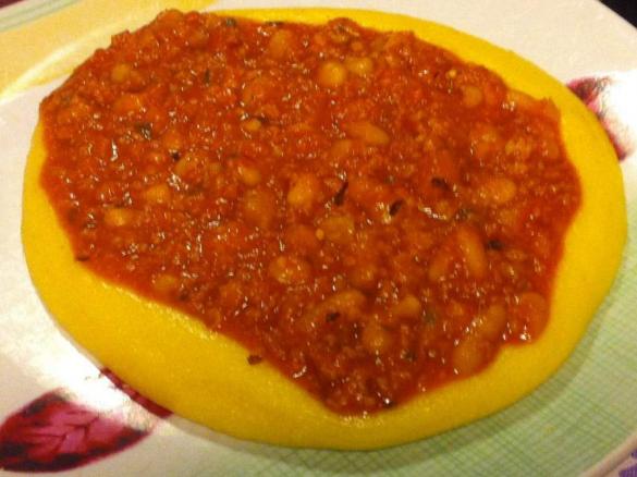 Beans with tomato and sausage on a bed of polenta